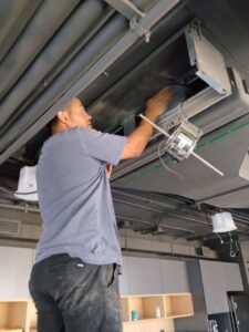 técnico haciendo mantención a fan coil