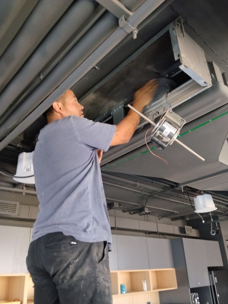 técnico haciendo mantención a fan coil